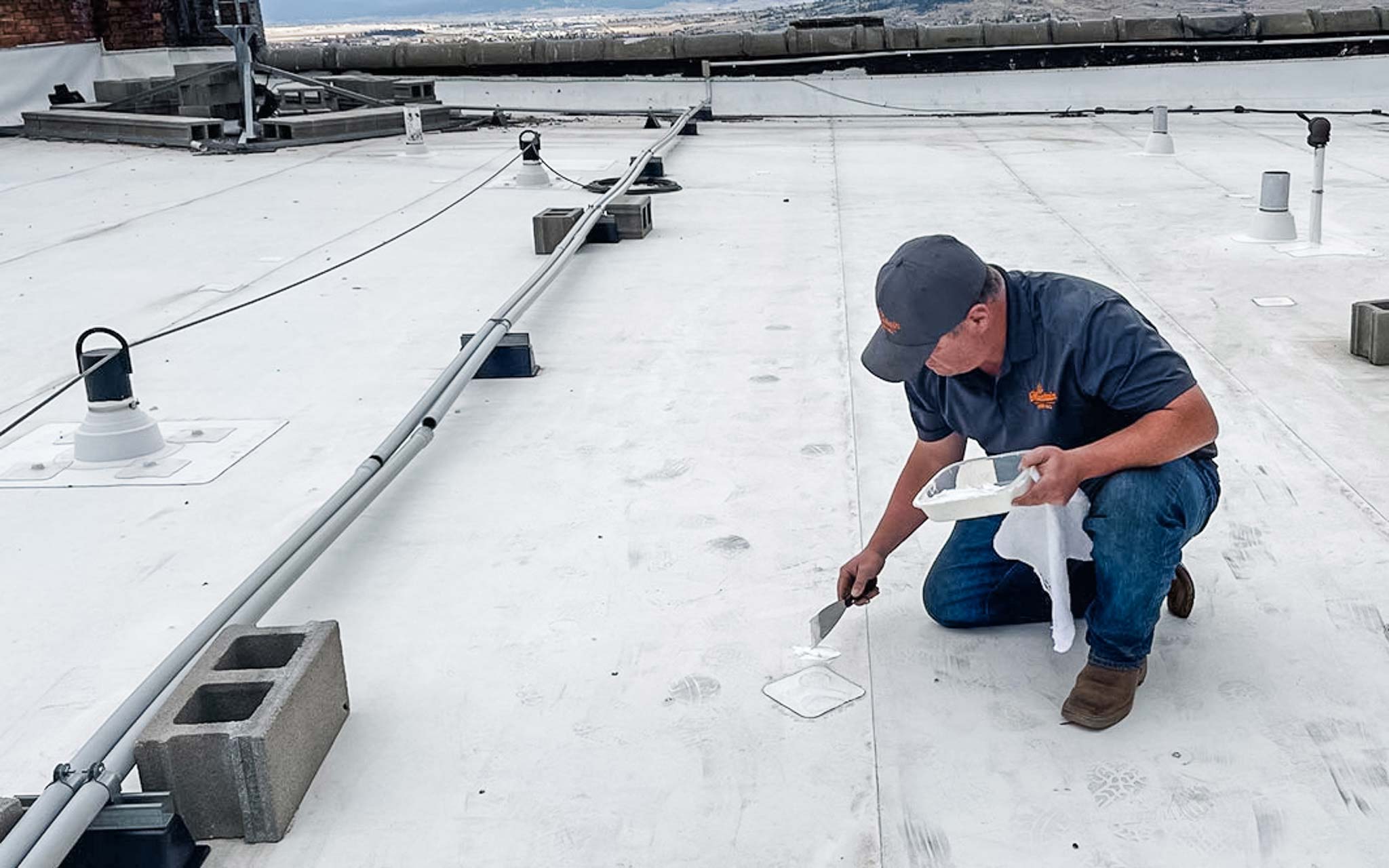 Always looking out for the owner, the Quality and Service Technician at Mountain Roofing patches a hole on a roof.