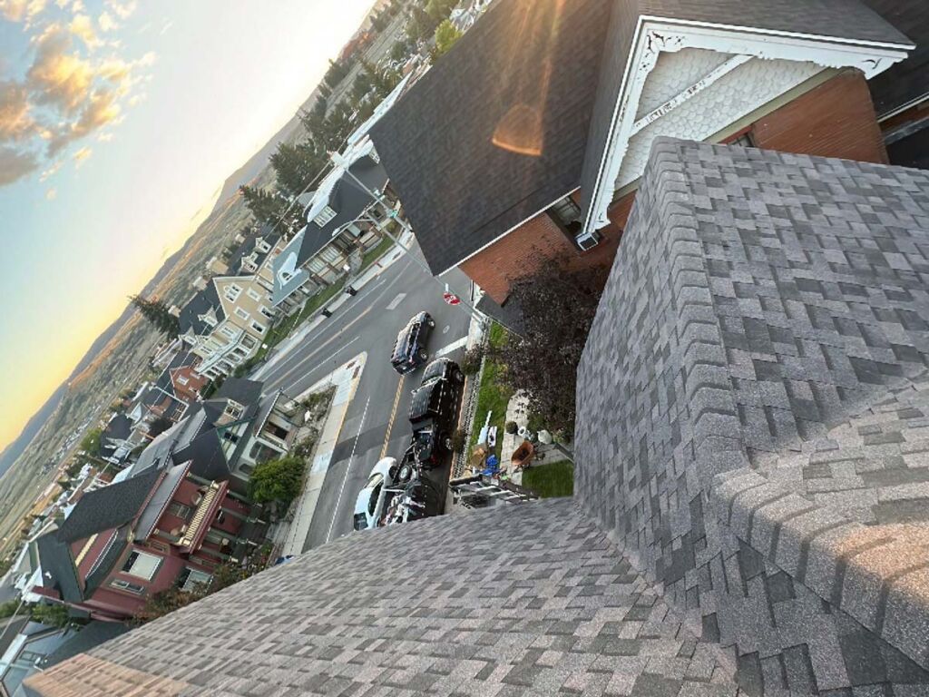 High above Granite Street in Butte, MT, the photo showcases the complexity that can be found on some historic houses. Mountain Roofing installed an Owens Corning Midnight Plum Roof showcasing one of these historic beauties. The photo is from the top of the roof looking down, multiple facets are visible with ridges and valleys.