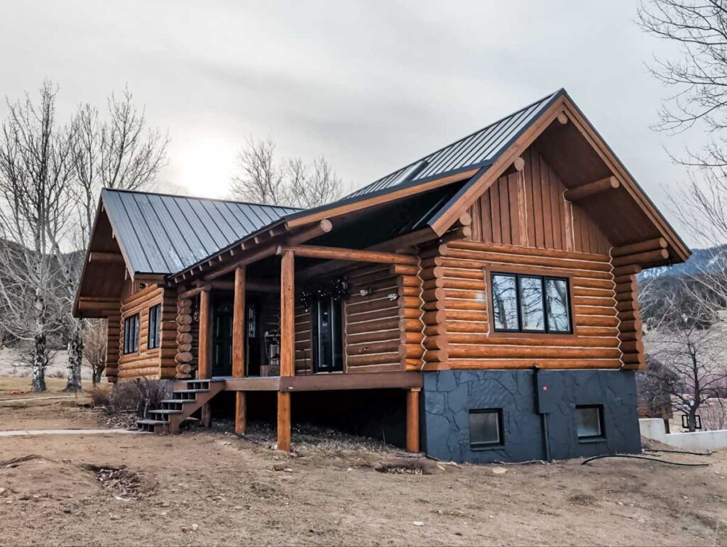 Mountain Roofing installed a Standing Seam Metal Roof in Matte Black on a log cabin style house.